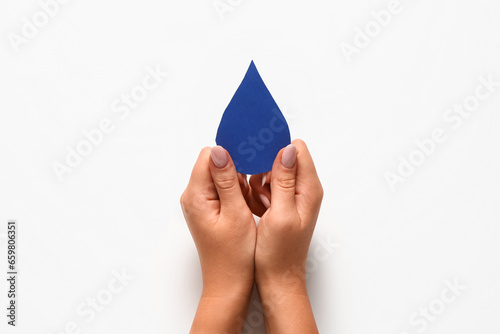 Canvas Print Female hands with paper drop on white background. World Polio Day