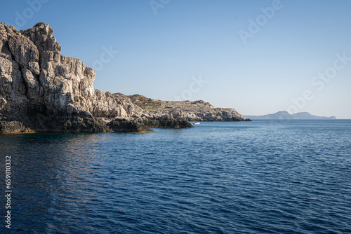 Majestic Rock Formations of Rhodes: A sea-level view of the stunning cliffs and geological wonders along the island's coastline, where the Mediterranean's blue embraces Grecian landscapes.