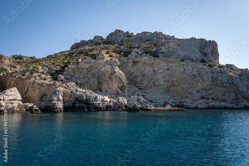 Majestic Rock Formations of Rhodes  A sea-level view of the stunning cliffs and geological wonders along the island s coastline  where the Mediterranean s blue embraces Grecian landscapes.