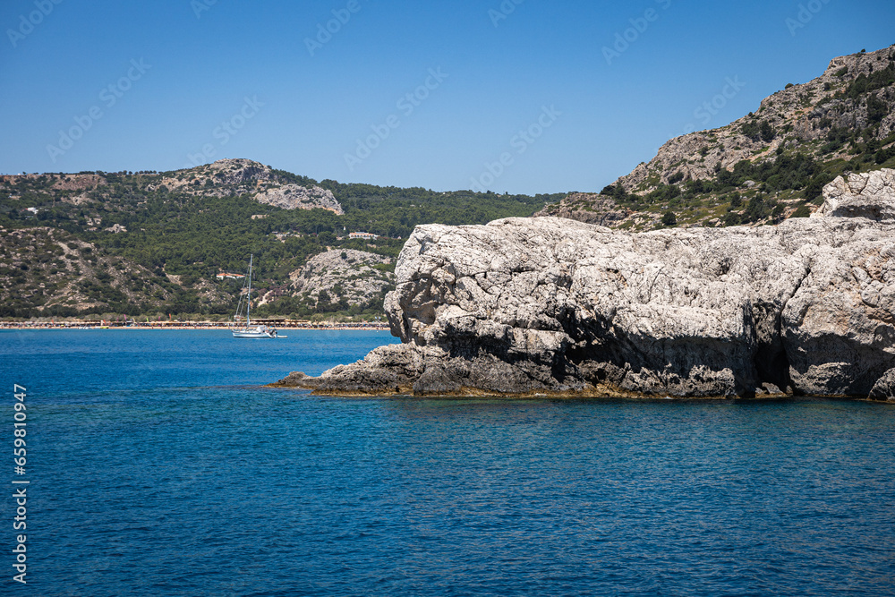 Majestic Rock Formations of Rhodes: A sea-level view of the stunning cliffs and geological wonders along the island's coastline, where the Mediterranean's blue embraces Grecian landscapes.