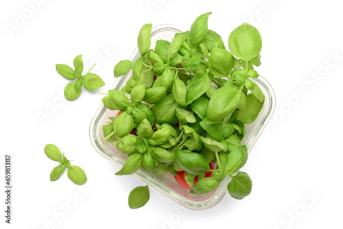 Glass bowl with fresh green basil and tomatoes on white background