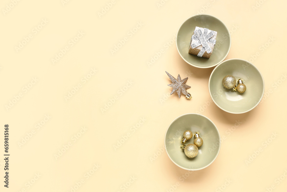 Beautiful table setting with Christmas balls and gift box on yellow background Beautiful table setting with Christmas balls and gift box on yellow background