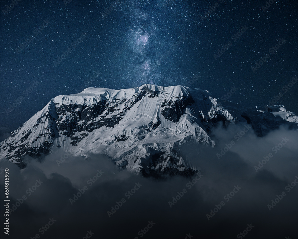 Milky Way above mountains in fog at night in autumn. Landscape with himalayan mountains, low clouds, purple starry sky with milky way 
