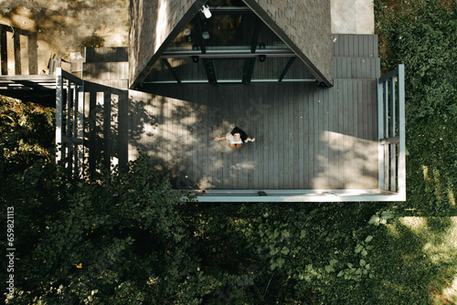 A woman rests and meditates in a house in the forest. Retreat and meditation concept