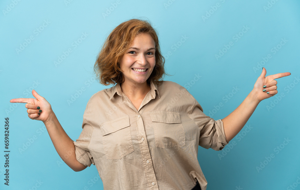 Young Georgian woman isolated on blue background pointing finger to the laterals and happy Young Georgian woman isolated on blue background pointing finger to the laterals and happy