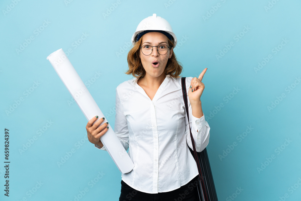 Young architect Georgian woman with helmet and holding blueprints over isolated background intending to realizes the solution while lifting a finger up