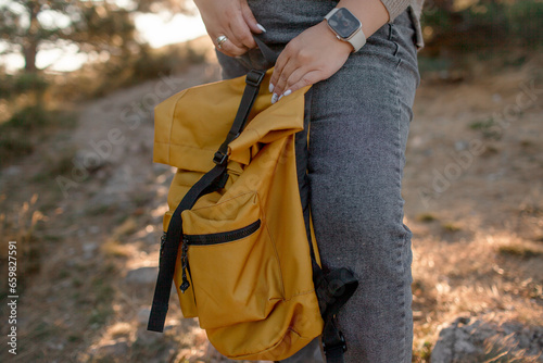 Close-up of womans hands holding yellow bagpack