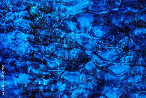 textured natural abstract background, water bubbles under a crust of ice, blue waves and bubbles