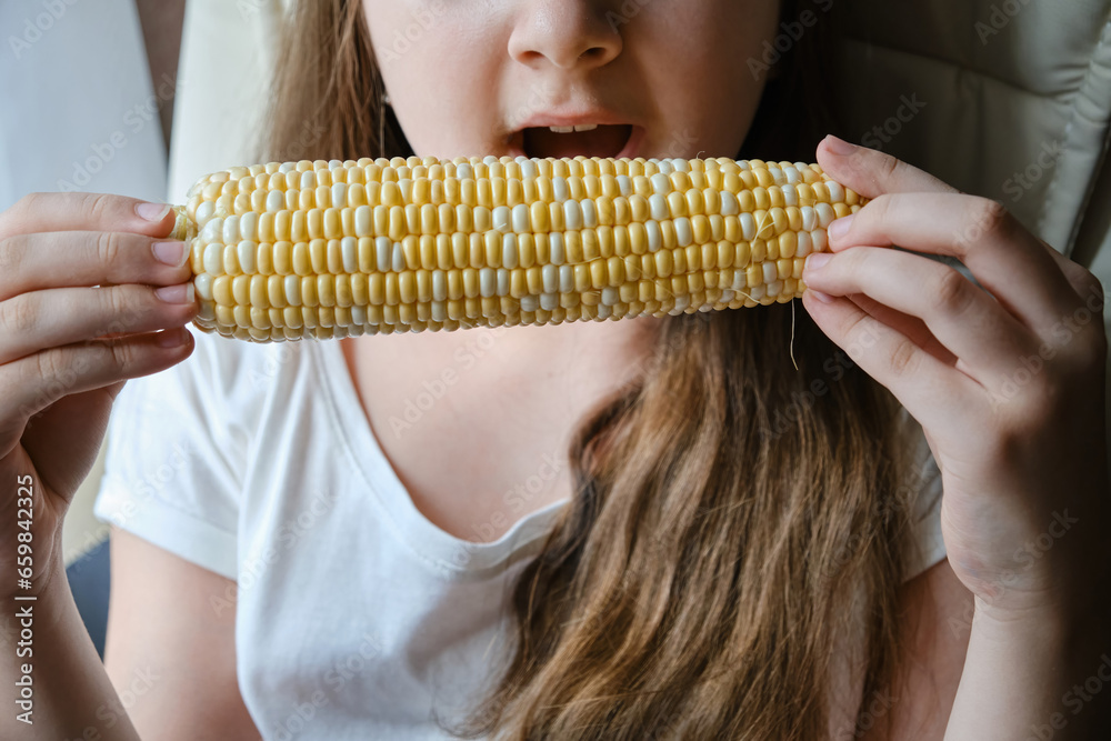 Portrait of adorable cute child girl biting big vegetable corn Portrait of adorable cute child girl biting big vegetable corn