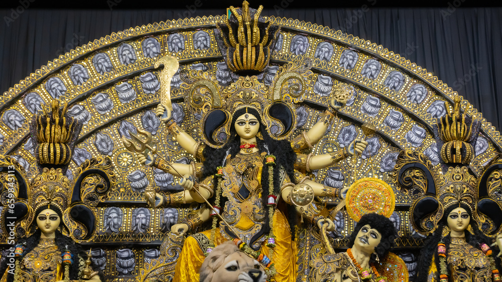 Howrah, West Bengal, India- 4th October, 2022 : Beautifully decorated Durga idol is being worshipped inside puja pandal. Durga Puja is biggest festival of Hinduism, celebrated all over the world.