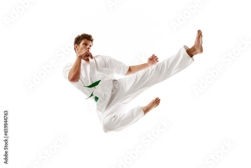 Flying kicks. Professional martial arts athlete, karateka in white kimono training, practicing isolated on white studio background. Concept of martial arts, combat sport, energy, strength, health. Ad
