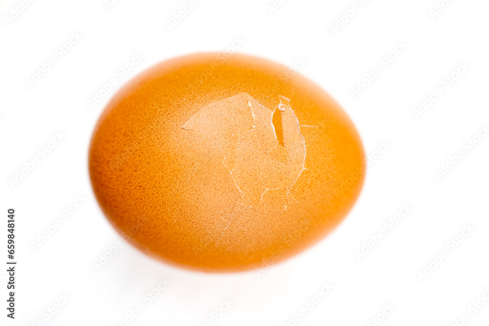 Cracked boiled egg with shallow depth of field on white background