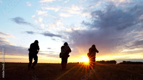 Silhouette of armed soldiers squad running and aiming enemy, military forces fight with arms. Weapon attack operation, war service and assault mission