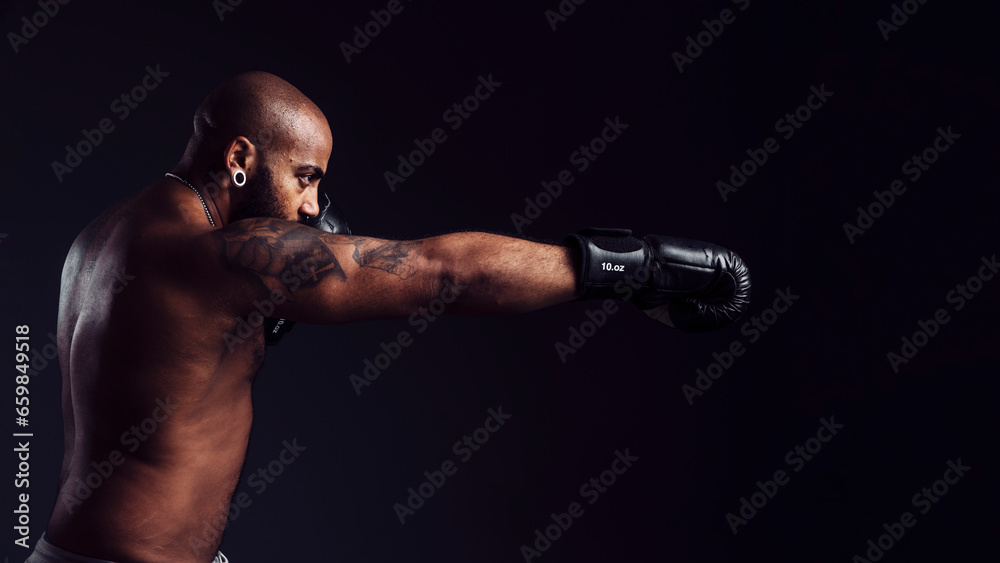 Mixed-race man throwing a cross into the air on a black background with boxing gloves