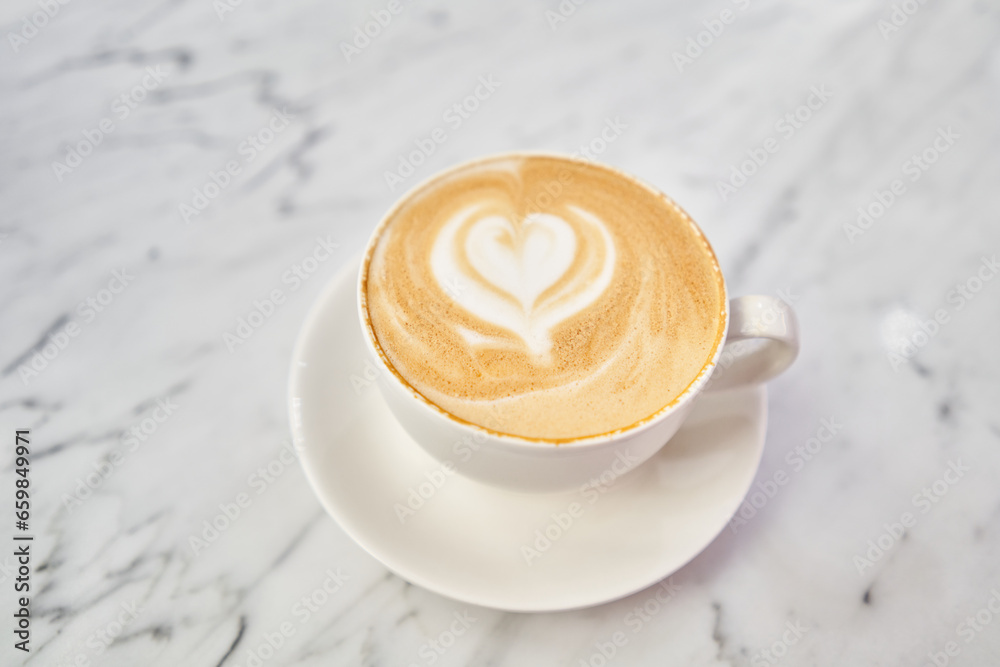  Cup of hot cappuccino. The table in the coworking space of the coffee shop. A cup of coffee on the veranda on a sunny day. Coffee break at the cafe. Close-up