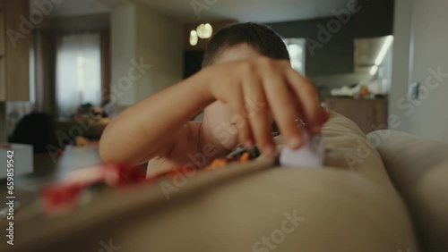 Wallpaper Mural Boy playing with colorful toy vehicles, sitting on the sofa in the living room. Toy cars. Exited boy. Happy family concept. Torontodigital.ca
