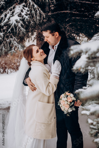 Winter wedding. Newlyweds walking outdoors at winter time