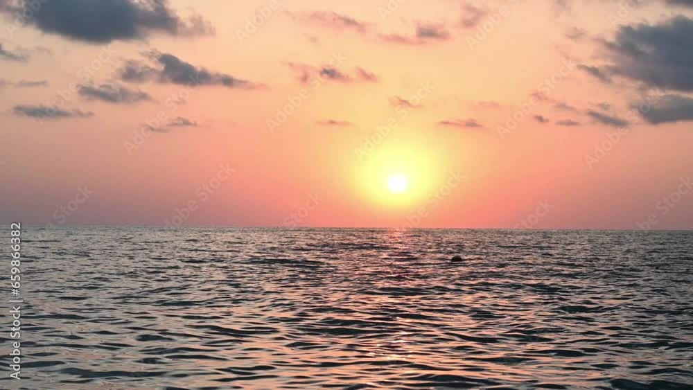 Beautiful warm sunset on the sea. Burning sky, clouds and shining sun over the sea horizon. 4k footage Beautiful warm sunset on the sea. Burning sky, clouds and shining sun over the sea horizon. 4k footage
