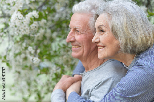 Portrait of beautiful senior couple hugging on a lilac background in the park