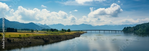 Breathtaking landscape: panoramic dam, mountain range, and vibrant blue sky view