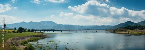Breathtaking landscape: panoramic dam, mountain range, and vibrant blue sky view