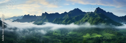 Incredible green mountain vista with fog enveloped midsection and cloud kissed summits