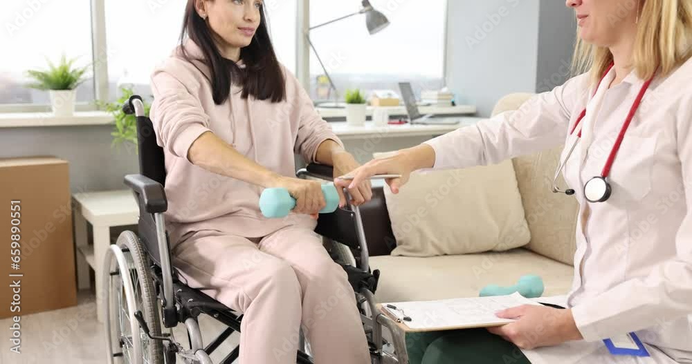 Doctor together with woman in wheelchair is doing physical exercises with dumbbells. Rehabilitation for people with disabilities concept Doctor together with woman in wheelchair is doing physical exercises with dumbbells. Rehabilitation for people with disabilities concept