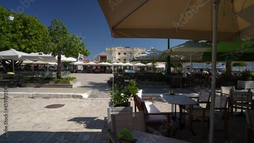 View of cafes and restaurants in Plateia Central Square through trees, Lixouri, Kefalonia (Cephalonia), Ionian Islands, Greek Islands photo