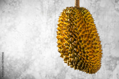 Durian fruit was photographed floating against the background of a cement wall.