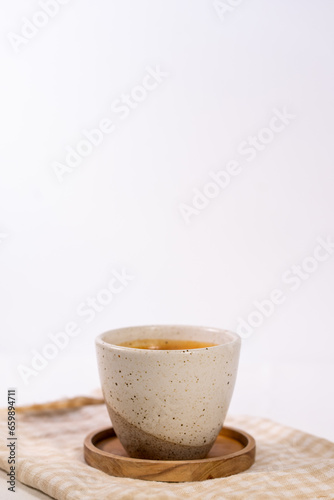 Cup of coffee served on a cloth on a wooden table—a simple and aesthetic concept.