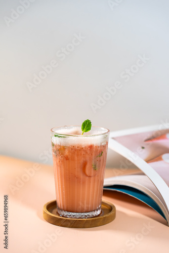 Mulberry cocktail served on a table with book ornaments.