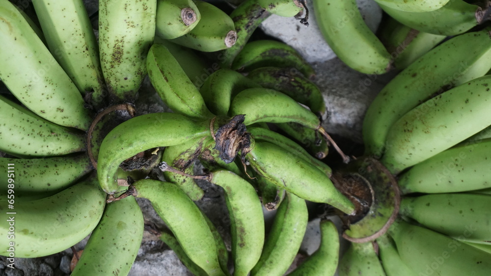 Green bananas on the market in Indonesia. Selective focus and shallow depth of field.