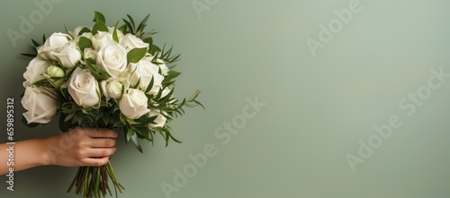 The bride holds a bouquet of roses with a gentle touch