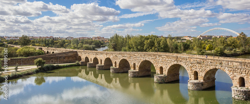 Panorama of the historic roman bridge reflecting in the Guadiana river in Merida, Spain