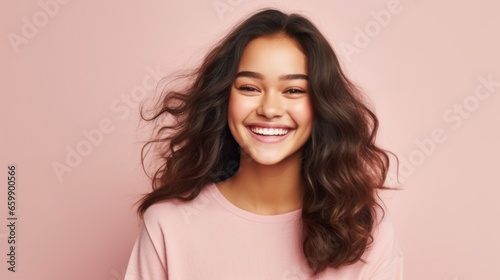 A striking portrait captures the essence of teenage exuberance as a girl smiles brightly against a clean studio background.