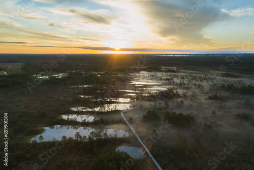 Nature of Estonia, sunrise on a swamp in summer. Fog over the lakes. View from a drone.