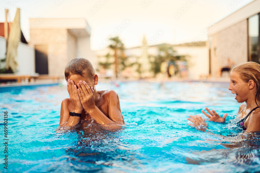 In a sunlit modern villa, a young brother and sister joyfully splash and play in the pool, basking in the warmth of a perfect summer day