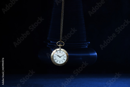 Hypnosis session. Vintage pocket watch with chain swinging over surface on dark background among faded clock faces, magic motion effect