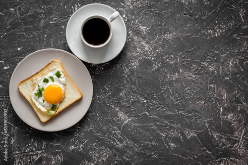 Fried eggs on toast bread and cup of black coffee, top view