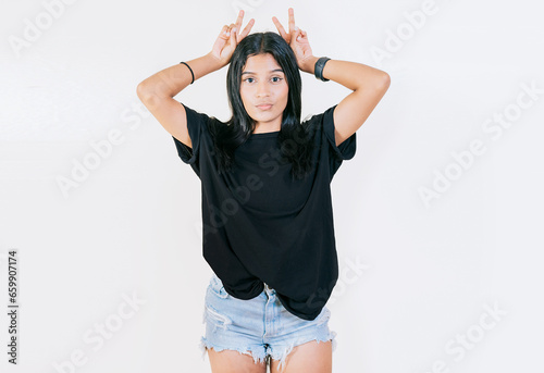 Young girl making horns gesture with their fingers, gesture of betrayal. Young woman making horns gesture with fingers. Infidelity concept © IHERPHOTO