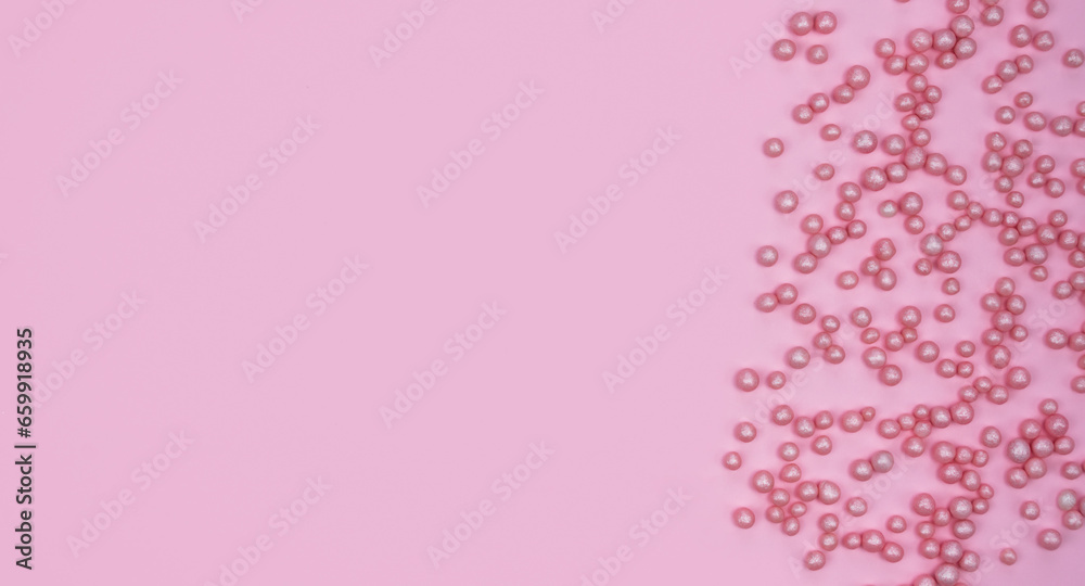 Minimalistic flatlay composition with pink decorative balls on a pink background. Holidays concept. Copy space. Top view.