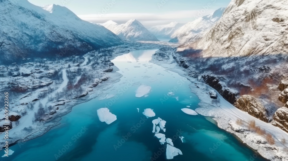 Mountain river on a beautiful sunny day. Snowy winter landscape of mountains with a cold clear river. Global Warming and melting ice concept. Beautiful drone shot of the river in the mountains.