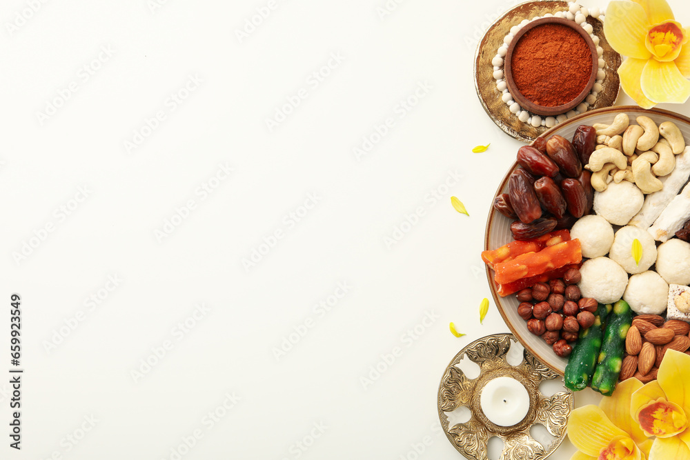 Plate with sweets, candle, flowers and spices on white background, space for text Plate with sweets, candle, flowers and spices on white background, space for text