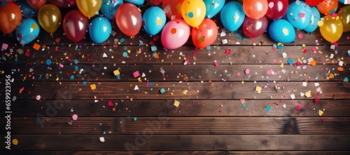Wooden backdrop embellished with bright balloons and confetti in a burst of colors