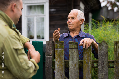 Senior man having conversation with his neighbour photo