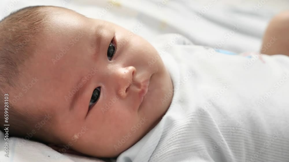 Portrait of cute little Asian newborn baby girl lying down on bed Portrait of cute little Asian newborn baby girl lying down on bed