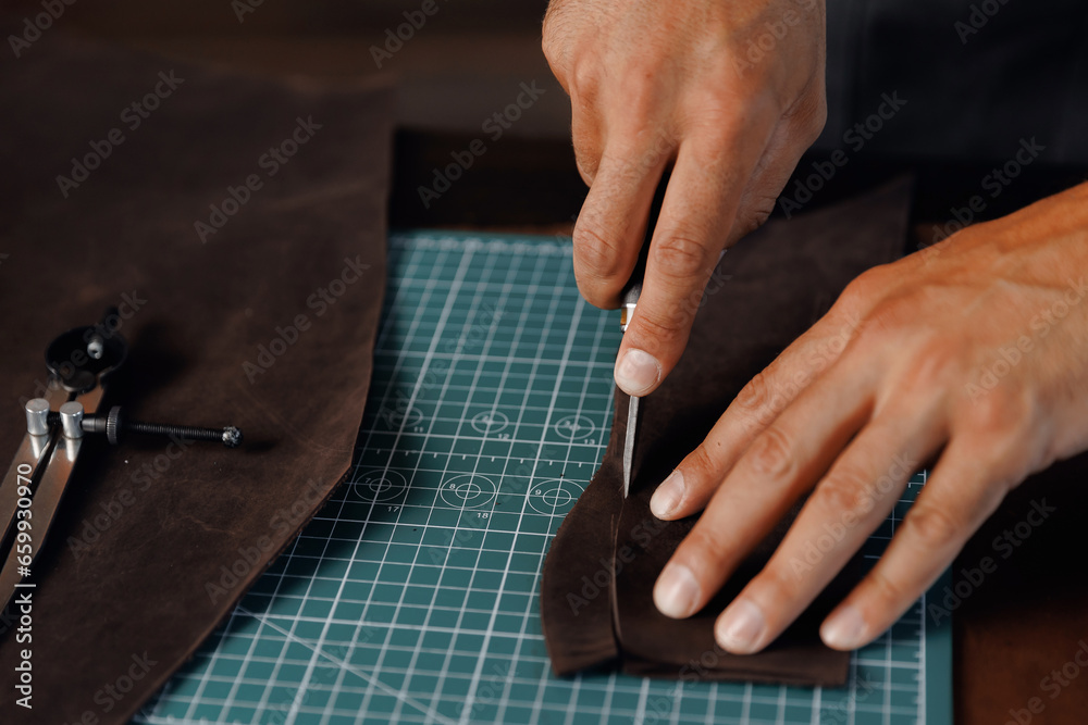 Obraz premium Closeup Hand of Tailor, cobbler use natural brown leather, shoemaker working with skin textile in workshop