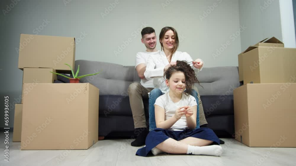 Happy family enjoying moving into a new, first purchased home, boxes with things nearby. Bank loan, affordable home for a young family Happy family enjoying moving into a new, first purchased home, boxes with things nearby. Bank loan, affordable home for a young family