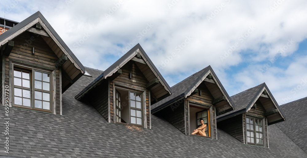 nude woman sits in the window opening of country house