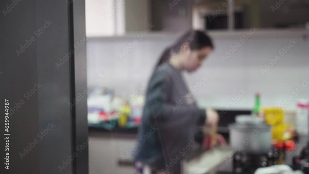 Blurred woman tidying up the kitchen. Woman organizing the kitchen Blurred woman tidying up the kitchen. Woman organizing the kitchen